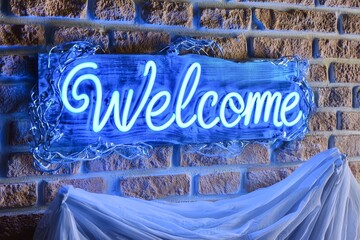Poster - Welcome, blue neon sign on brick wall background.