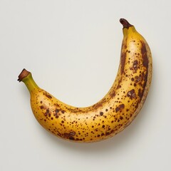 Aufkleber - Ripe yellow banana with brown spots resting on a light surface for a fresh fruit experience