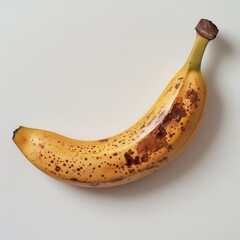Aufkleber - Ripe yellow banana with brown spots resting on a light surface in a kitchen setting