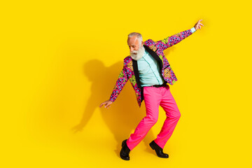 Wall Mural - Photo of glad crazy showman dressed trendy pink suit dance evening festive event empty space isolated on yellow color background