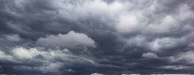 Fototapete - A dark and ominous sky filled with heavy clouds suggests bad weather approaching, symbolizing stormy conditions, atmospheric tension, and the unpredictable nature of the night.