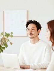 Aufkleber - Minimalist Home Office Setting Asian Professional with Laptop, Natural Light and Greenery - Modern Remote Work Efficiency and Eco-Conscious Space Design