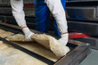 © Parilov - Industrial factory worker handling insulation material with precision