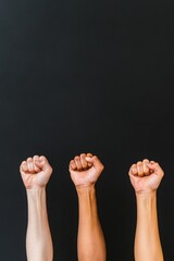 Poster - Unity in Diversity Raised Fists of Different Skin Tones Against Black Background
