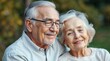 © Tata - Elderly grandparents enjoying each other's company with warm smiles in a serene garden setting