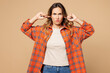 © ViDi Studio - Young sad mad woman she wear orange shirt casual clothes cover ears with hands fingers do not want to listen scream isolated on plain pastel light beige background studio portrait. Lifestyle concept.