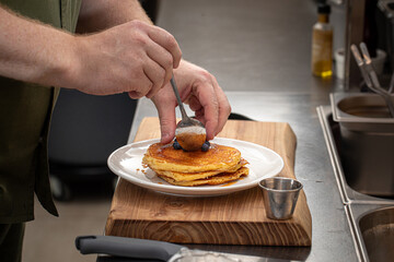 Wall Mural - Chef serving sweet blueberry pancakes for the client