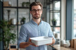 © Татьяна Евдокимова - Young businessman holding a white plastic food container, perfect for meal prepping and showcasing healthy eating habits
