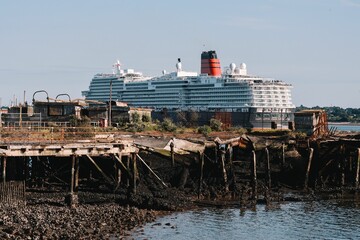 Canvas Print - Cruise ship on a harbor behind muddy shoreline