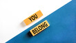 © Dzmitry - Belonging and you belong symbol. Concept words You belong on beautiful wooden blocks. Beautiful white and blue background. Business belonging and you belong concept. Copy space.