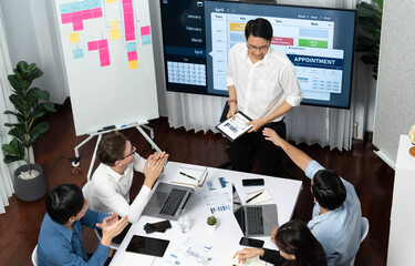 Leinwandbilder - Project manager communicate and collaborate with team using project management software display on monitor, tracking progress of project task and making schedule plan at meeting table. Prudent