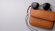© Kritsadee - Stylish sunglasses and chic bag display minimalist setting product photography modern aesthetic