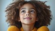 © Kaizenart - Young girl with curly hair gazing upwards in a bright room, conveying joy and curiosity