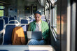 © DimaBerlin - Man works on laptop during morning commute on train, remote freelance with WiFi in public transport. Male uses his free time while commuting to work by doing work-related tasks on computer.