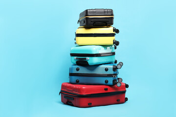 Wall Mural - Stack of colorful suitcases on light blue background