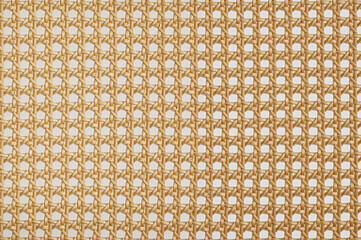 light brown cane webbing forms a repeating grid pattern.