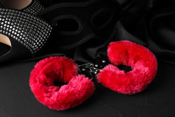 Wall Mural - Red fluffy handcuffs, mask, shoes and fabric on black surface