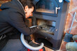 © ADDICTIVE STOCK - Asian woman cleaning a modern wood burning stove