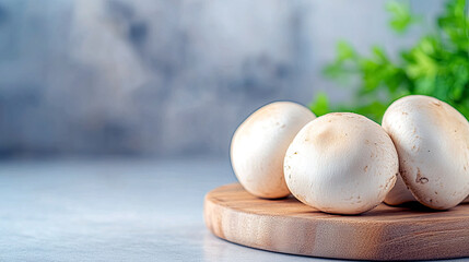 Poster - Smooth White Button Mushrooms Resting on a Wooden Cutting Board in a Minimalist Kitchen Setting