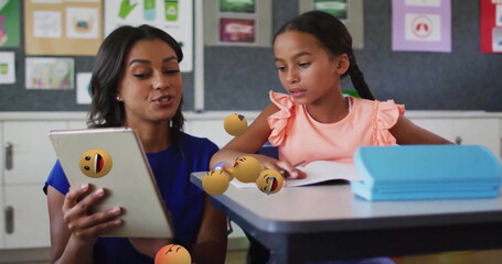 Poster - Image of emoji icons over biracial schoolgirl and teacher using tablet