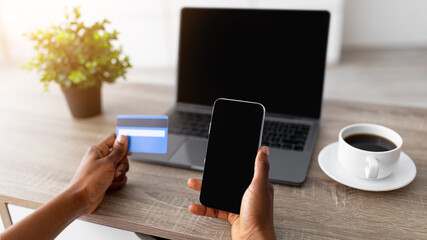 Poster - Closeup of young black lady with smartphone, laptop and credit card shopping online, using new mobile app or website to order goods on internet from home during covid quarantine, mockup for design