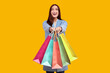 © Prostock-studio - Excited Girl Showing To Camera Colorful Shopping Bags Isolated Over Pastel Yellow Studio Wall, Copy Space