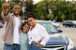 © Prostock-studio - New Car. Happy Black Family Showing Own Automobile Key To Camera Standing Near Auto Posing Outdoor. Vehicle Purchase And Rent, Dealership Advertisement Concept