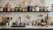 © Julia - Front view of marble countertop with black sink near light ceramic wall and gray furniture in nordic style kitchen. Various jars with food and cooking utensils on stone surface.