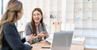 © NAMPIX - Two business women working together with laptop while talking in the coworking place