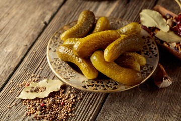 Canvas Print - Pickled cucumbers with ingredients on an old wooden table.