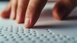 © milkyway - Hand Gently Touching Raised Braille Dots on Smooth Surface Symbolizing Accessibility and Inclusion