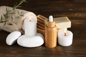 Sticker - Bottle of essential oil, burning candles, soap, spa stones and towel on wooden background