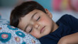 © pattozher - Peaceful Slumber: A close-up shot of a young boy peacefully sleeping on a pillow, his face serene and relaxed. The image evokes a sense of calm and tranquility.