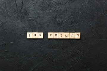 tax return word written on wood block. tax return text on cement table for your desing, concept