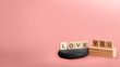 © Leo Lintang - Text of Love You in wooden cubes on a colored background. Copy space. Valentine greeting card. Decoration for Valentine celebration