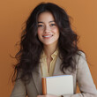 © JONATHAN - Confident Businesswoman Holding Notebook on Warm Orange Background