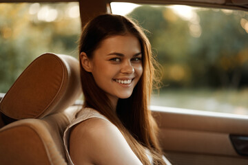 Poster - Young woman smiling in a car with a sunny background, showcasing a carefree summer vibe, embodying joy and happiness.