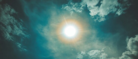 Aufkleber - Bright sun surrounded by a colorful halo against a dramatic sky filled with wispy clouds