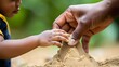 © Wilasinee - Close up of a parent guiding a child s hand to build a sand structure focusing on the interaction education and bonding between