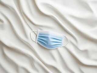 Poster - Sleek Minimalist Health Display Blue Medical Mask on Smooth White Fabric - Essential Safety Visuals for Modern Healthcare Marketing and Office Wellness Plans
