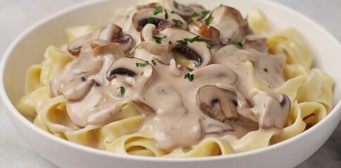 Creamy pasta with sautéed mushrooms, served in a bowl, makes for a delightful home meal