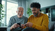 © Maksym - An elderly man is shown how to adjust settings on his digital hearing aid by a supportive caregiver in a modern living room, their bond evident in their shared expressions of patie