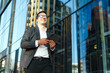 © muse studio - Businessman walking confidently in urban setting with tablet during daytime