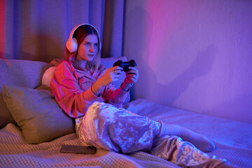 Wall Mural - A teenage girl enjoys a fun gaming evening, immersed in her vibrant room's light.