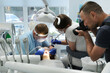 © Oleksandra - Dental treatment. Woman on dental examination. Professional equipment in dental clinic. photographer takes pictures of dental treatment process videographer shoots video man