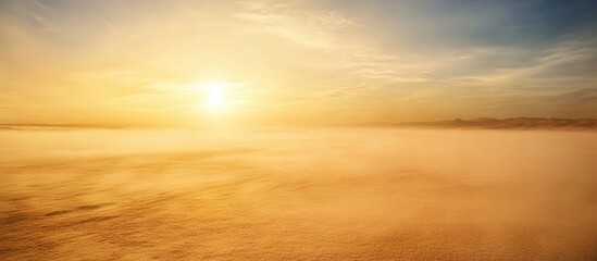 Poster - Sunrise over misty landscape with warm golden hues and soft clouds against a clear blue sky Copy Space