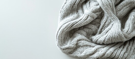 Poster - Cozy grey knitted sweater folded on a light surface with copy space for text placement