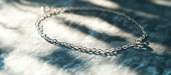 Poster - delicate silver chain bracelet on textured surface with soft shadows and highlights copy space
