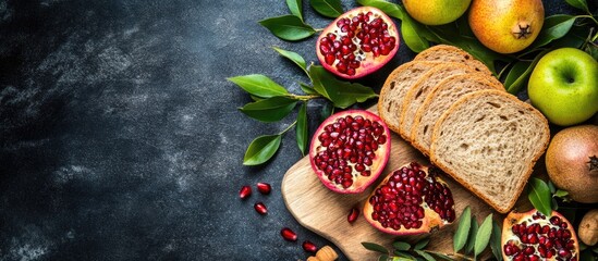 Poster - Fresh fruits and bread on a dark stone background with green leaves Copy Space for text or graphics