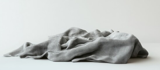 Poster - Crumbled grey fabric resting on a white background with ample copy space for text placement